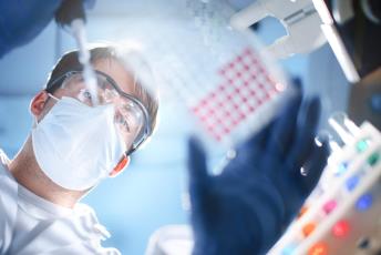 Scientist Examining a Microtiter Plate in a Laboratory