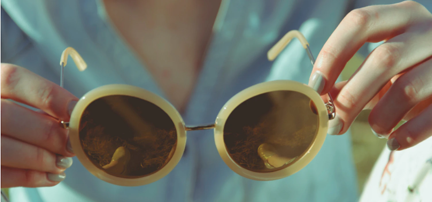 orig woman holding round sunglasses during daytime unsplash 749