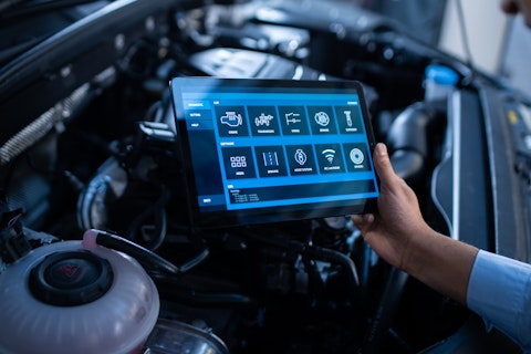 Mechanic Using a Tablet Computer with a Futuristic Interactive Diagnostics Software