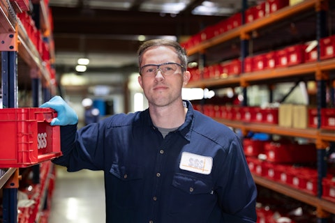 Worker in a warehouse holding a red crate