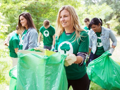 Woman Volunteer with Friends Cleaning Area in Park