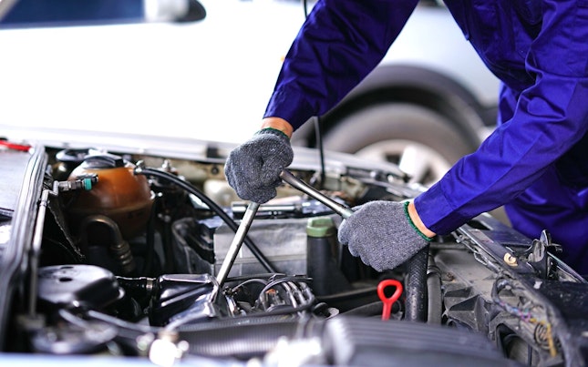 Auto Mechanic Using Repair Tools in a Garage