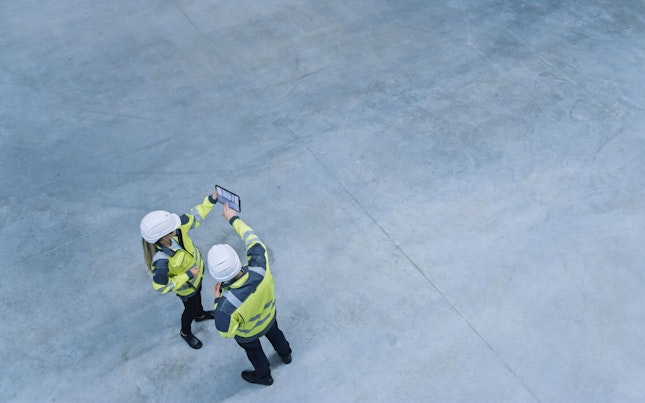 Construction Engineers Inspecting a Site Using a Software on a Digital Tablet