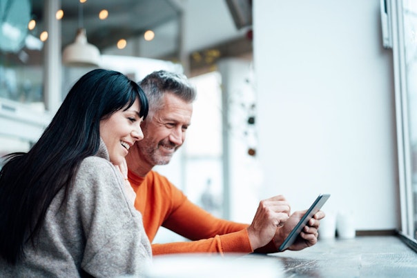 Couple Using Smart Phone at a Cafe