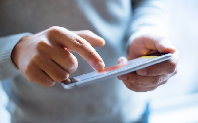 Man Holding External Battery and Smartphone
