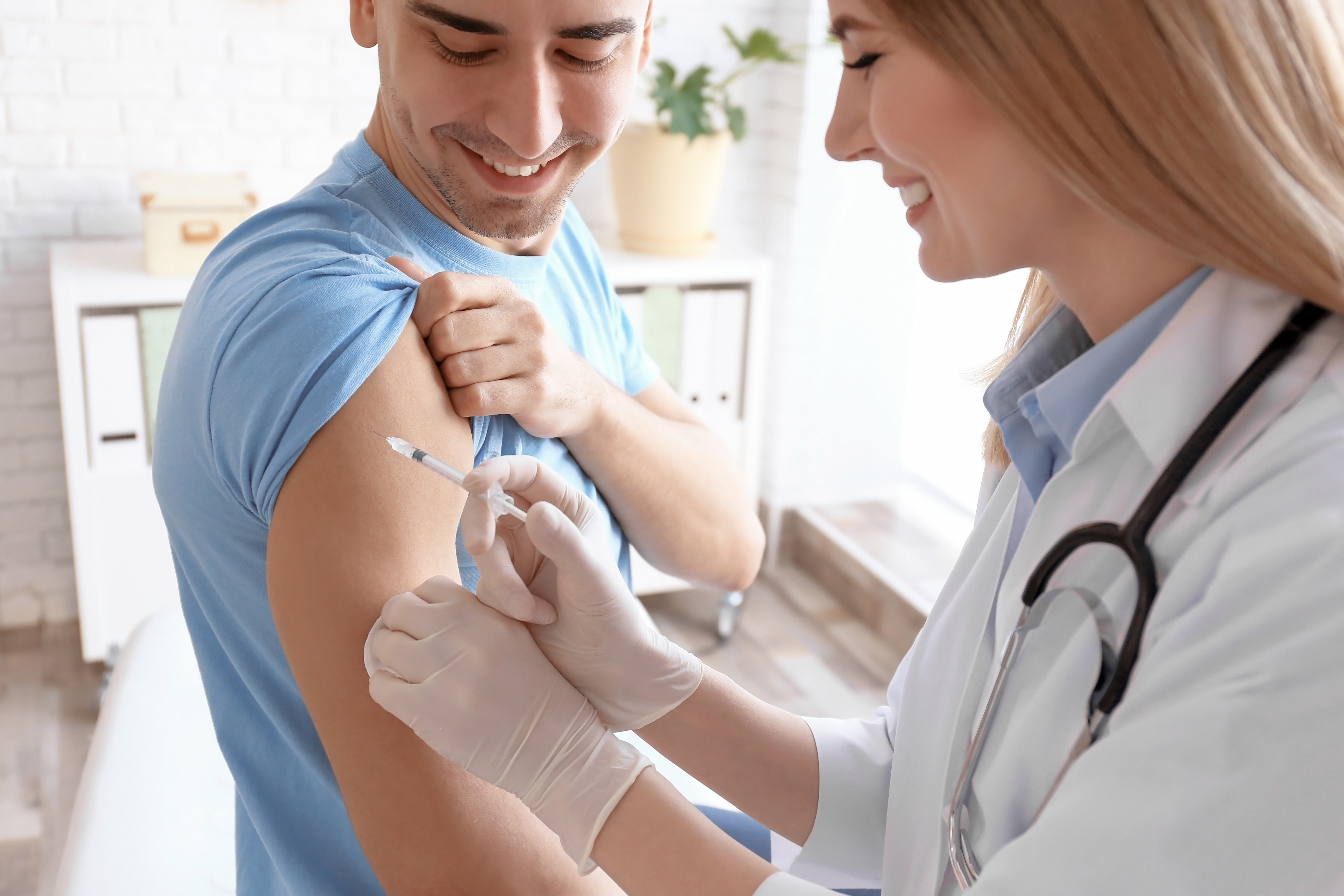 Médico inyectando la vacuna al paciente