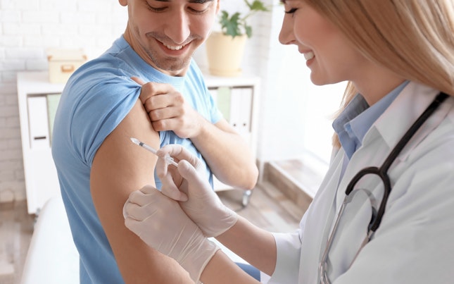 Médico a injetar vacina em paciente