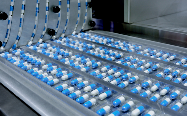 Blue capsules in a belt rotary factory machine