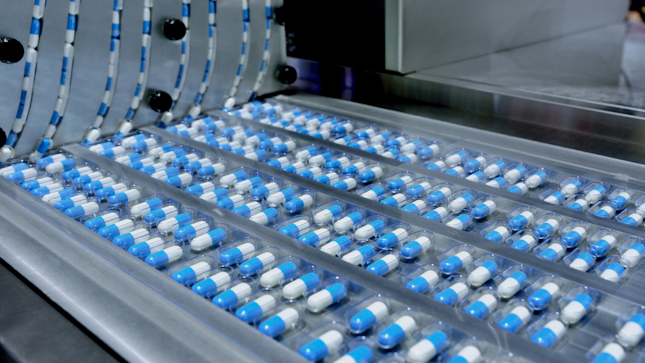 Blue capsules in a belt rotary factory machine