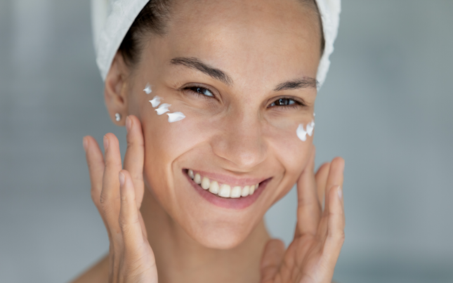 Mujer aplicándose crema facial
