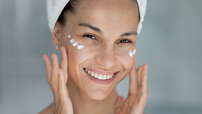 Mujer aplicando crema facial