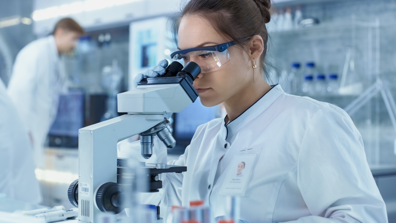 Mujer observando a través de un microscopio en un laboratorio