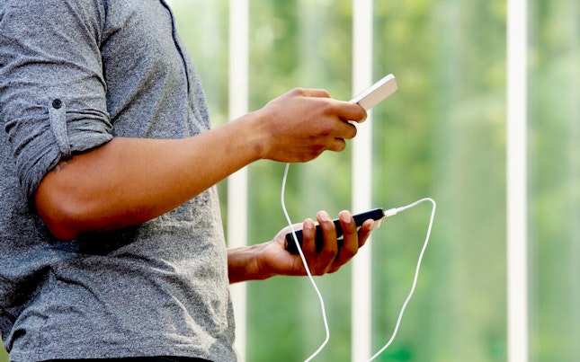 Mężczyzna trzymający zewnętrzny akumulator i smartfon