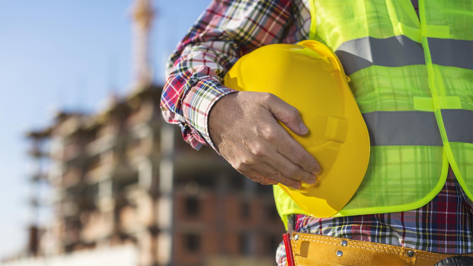 Hombre sosteniendo un casco amarillo