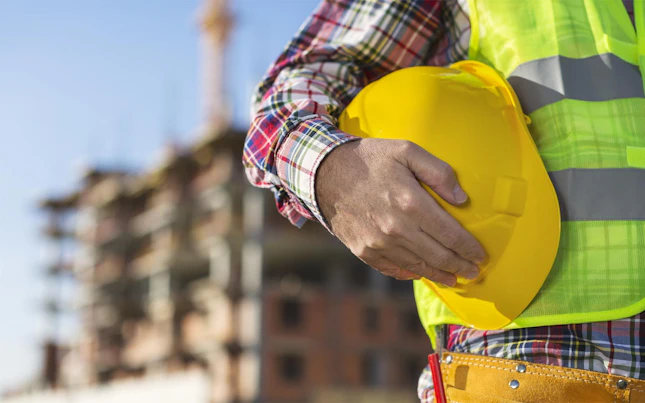 Hombre sosteniendo un casco amarillo
