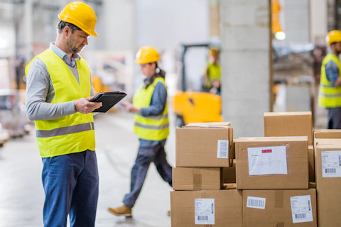 Man in Safety Vest Checking Boxes