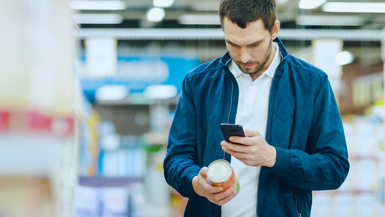 Bărbat ținând în mână o baterie externă și un smartphone 