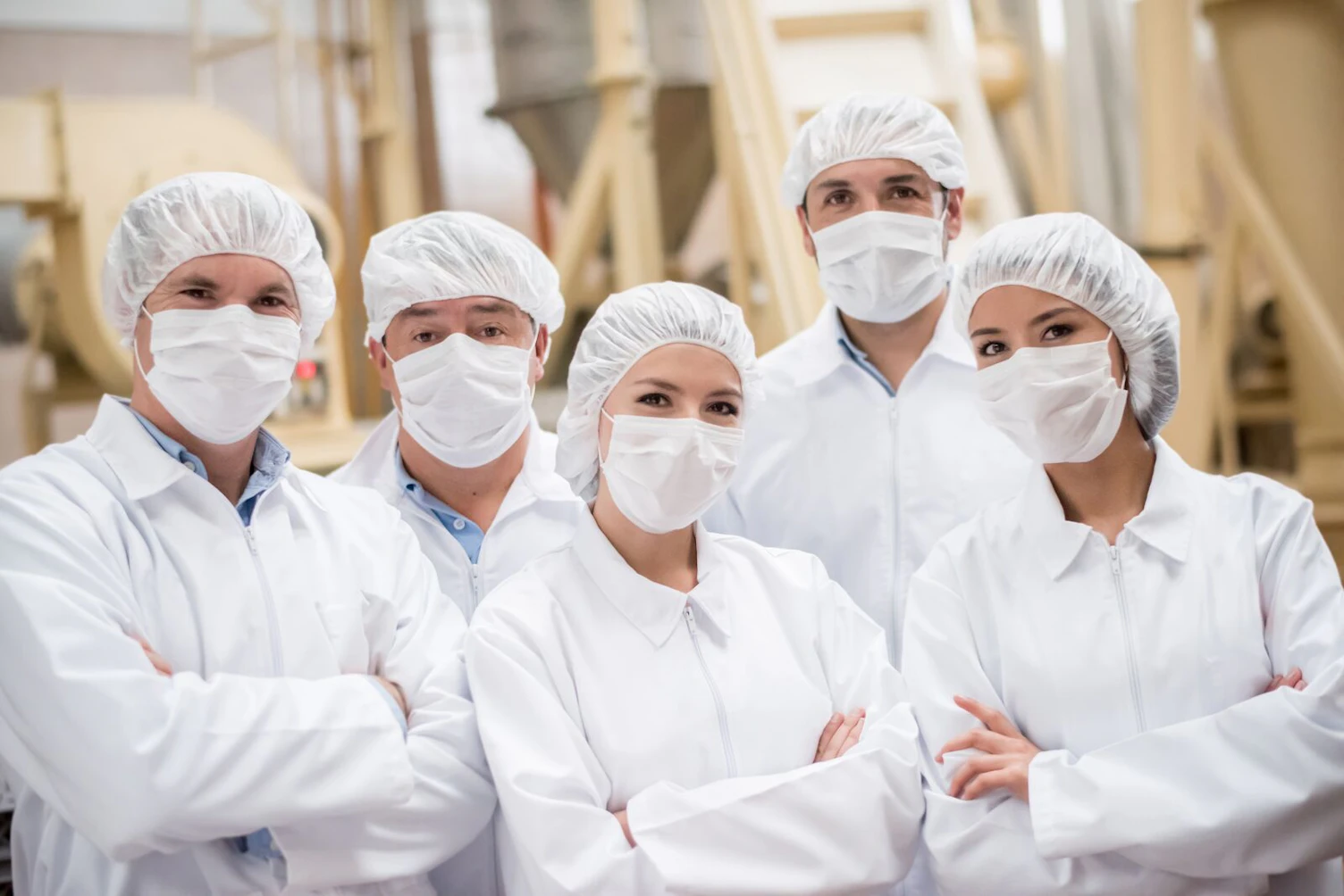 Group of Latin American people working at a food factory and wearing uniform