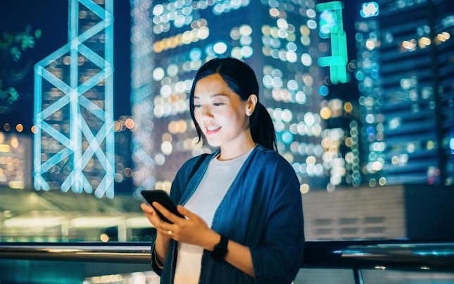 Mulher a usar o smartphone ao ar livre