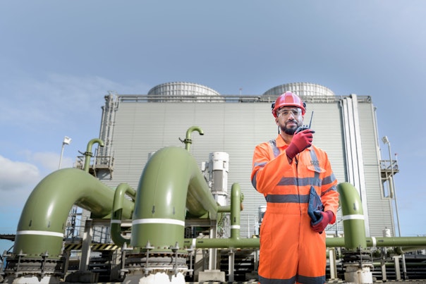 Worker Using Walkie Talkie in Powerstation Logo Added