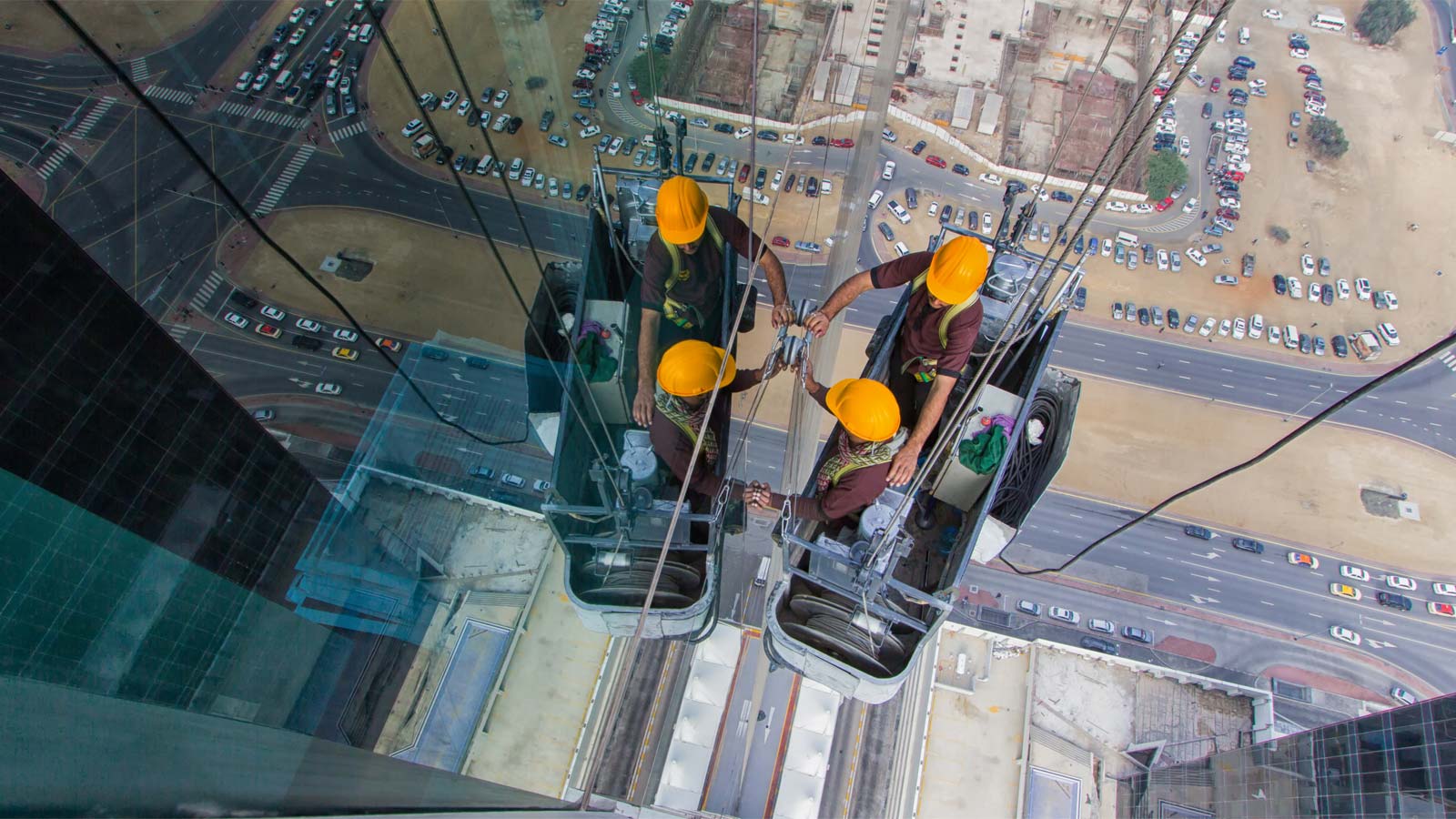 Workers cleaning window of tall building