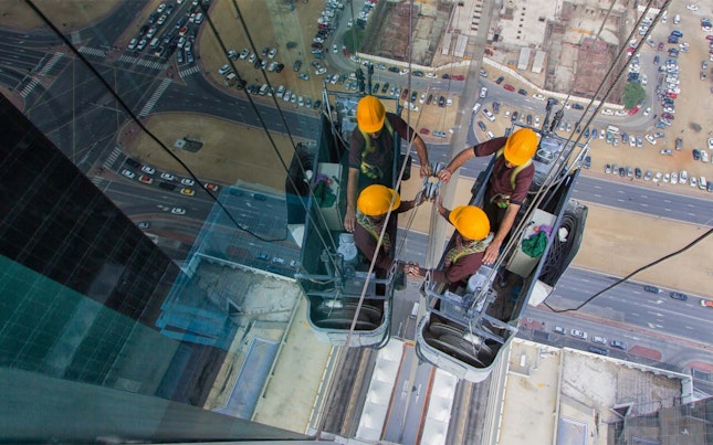 Trabajadores limpiando la ventana de un edificio alto